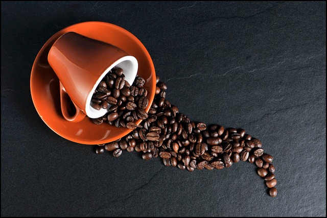 Una taza de granos de café se derramó de una taza de café