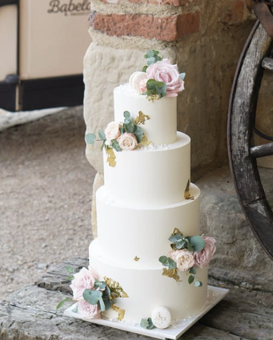 a wedding cake with a white and pink flowered cake