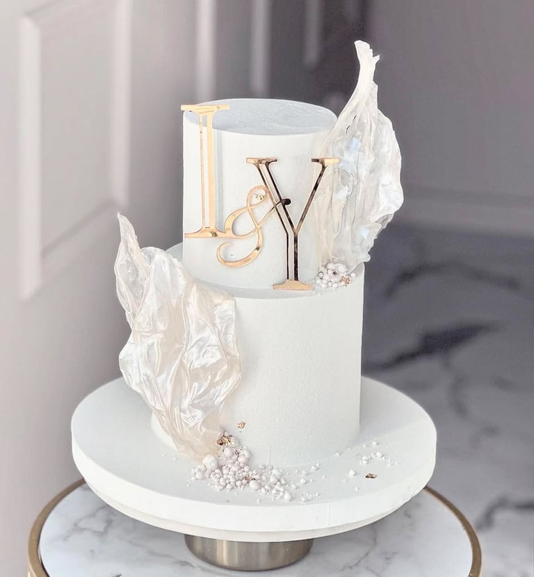 a white cake with a gold and silver cake topperf