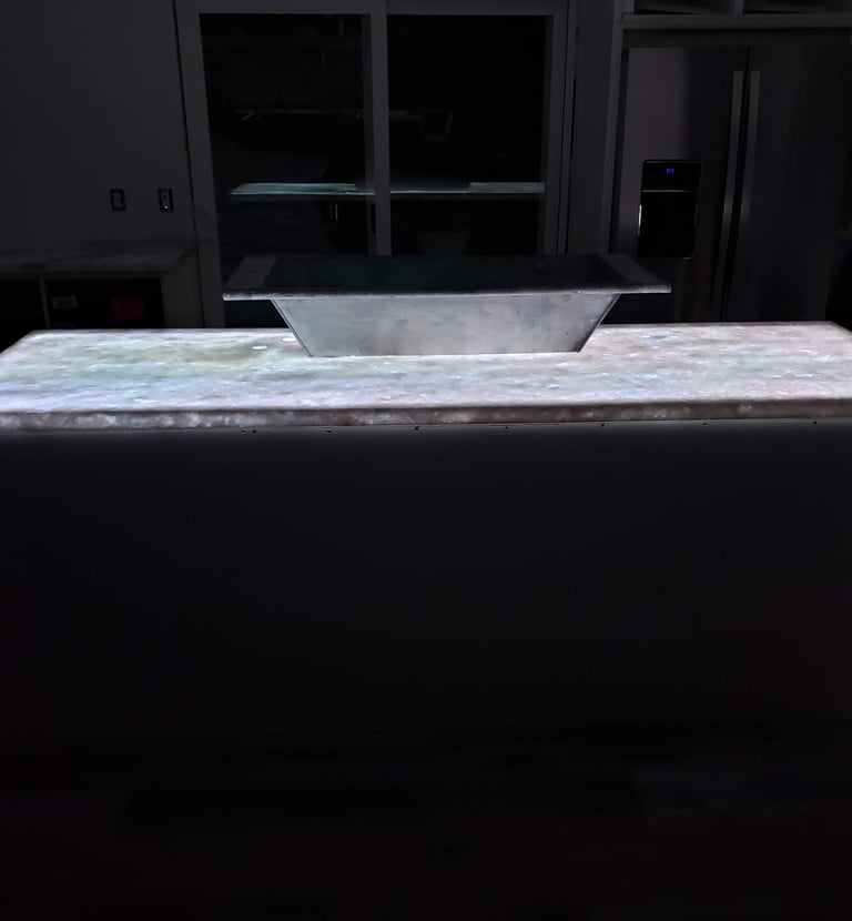 Kitchen remodel highlighting translucent quartz waterfall island countertop with color changing LED lights underlaid.  