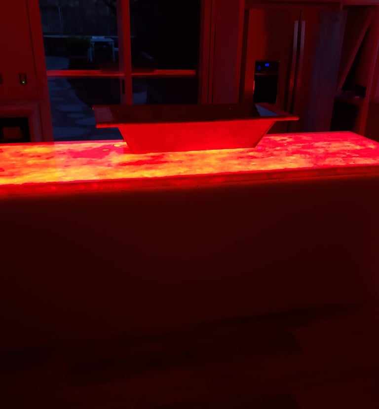 Kitchen remodel highlighting translucent quartz waterfall island countertop with color changing LED lights underlaid.  