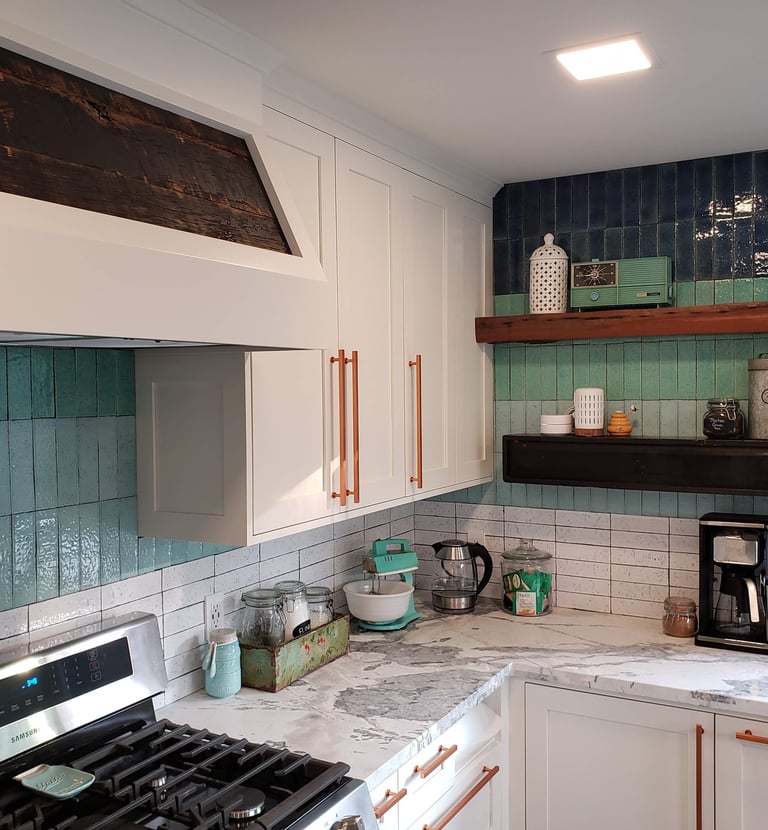 Renovated kitchen with custom vent hood, white and gray quartz counter tops, blue hombre tile work. Colorado Springs Kitchen.