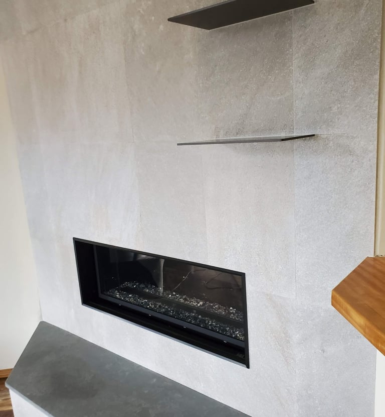 Sleek gas fireplace surround with slate shelves and hearth. Colorado Springs fireplace remodels.