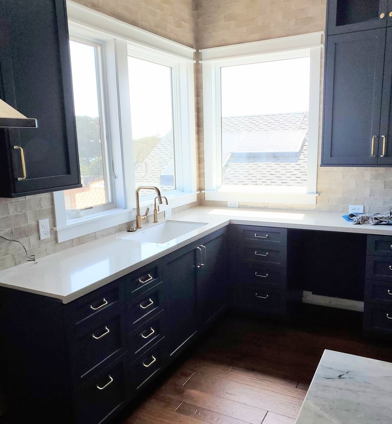 Modern renovated kitchen with custom black cabinetry and brass hardware. Colorado Springs kitchen update.