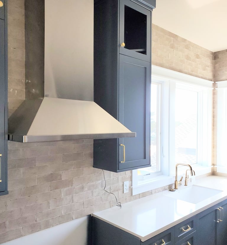 Remodel of kitchen.  Vent hood, black cabinetry, and white counter tops. Colorado Springs.