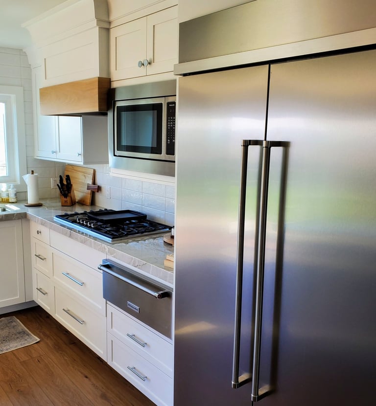 Remodeled kitchen with quartz countertops, white cabinetry with built in oven.  Custom space for stainless fridge. El Paso CO