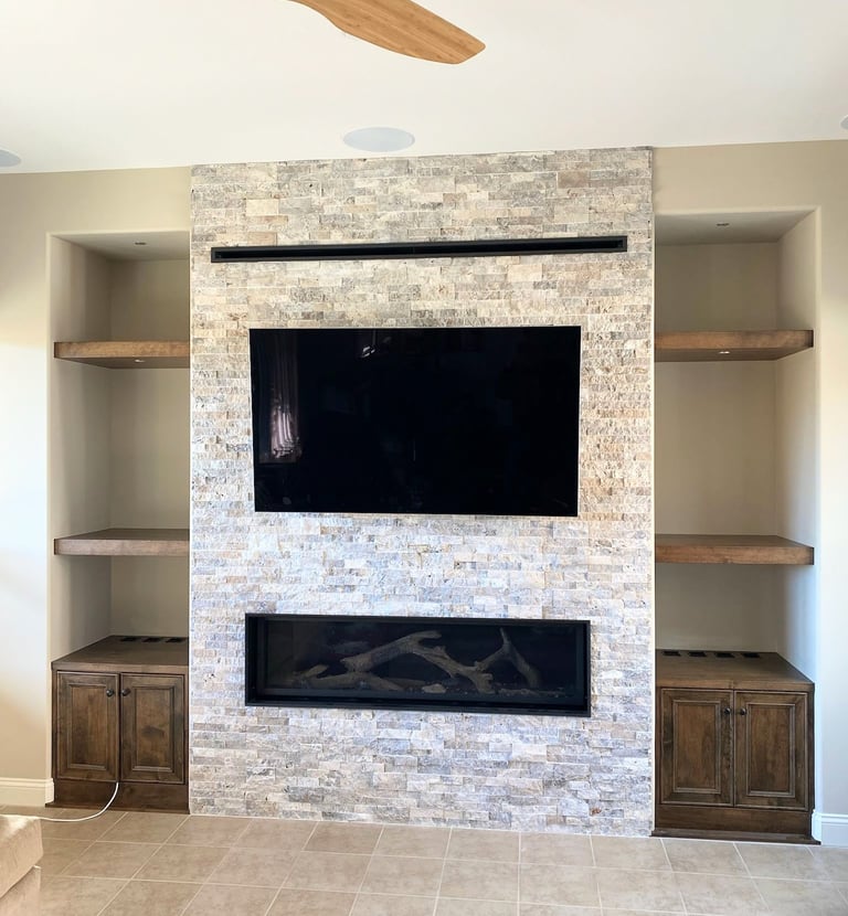 stone work fireplace surround with large mounted TV.  Custom shelving on either side. Colorado Springs fireplace updates.