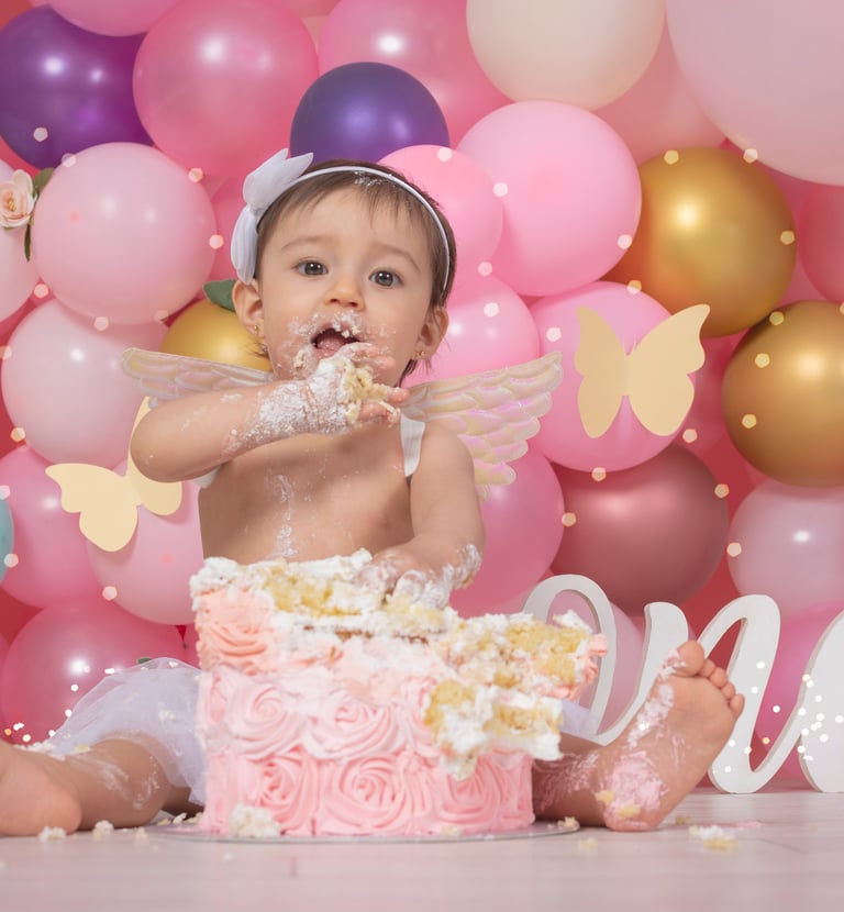 a baby girl sitting in front of a cake