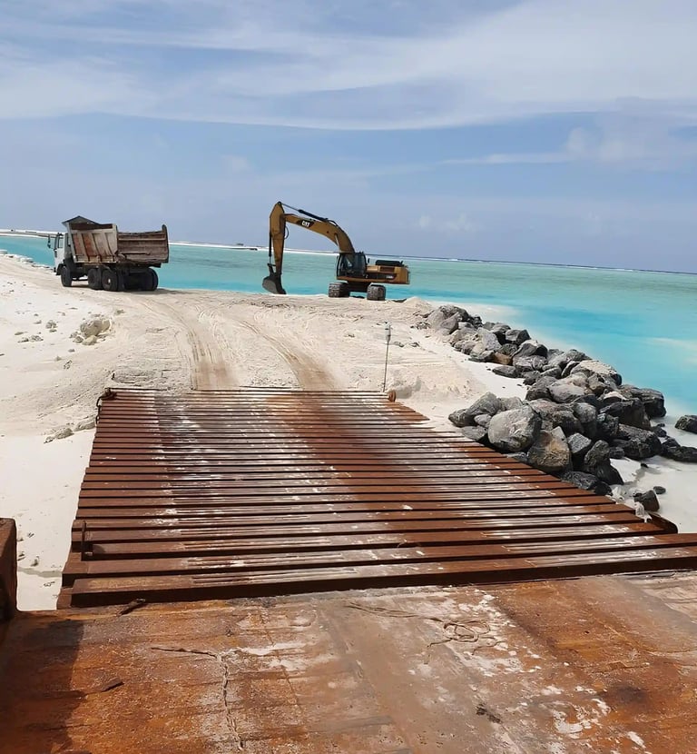 a construction worker is working on a beach with rock boulders in Maldives