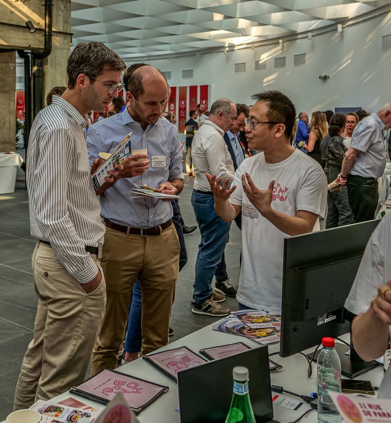 Trois hommes devant un stand qui discutent d'une entreprise qui frabrique des Baos