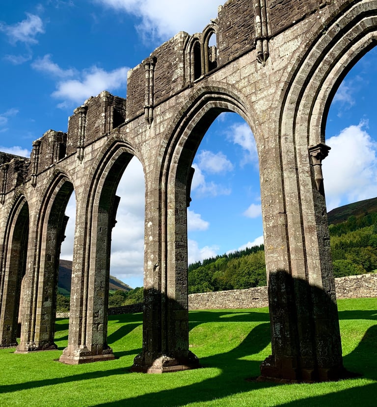 Llanthony priory in the sunshine with the Black Mountains behind it.