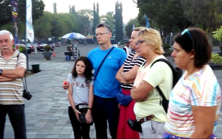 a group of people standing in brief around a group of european client