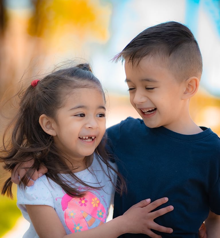 un garçon et une fille sourient et s'embrassent