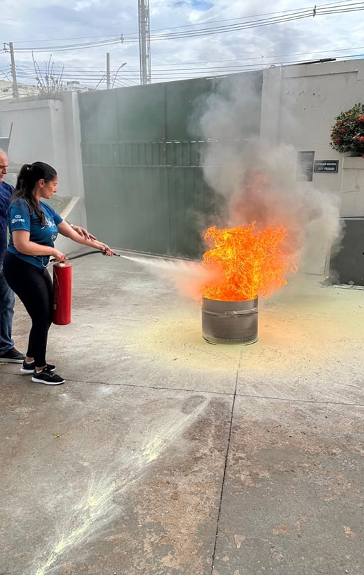 Mulher usando extintor - brigada de incêndio