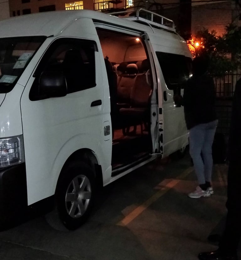 A white passenger van with Vanna Ventures for group airport transfer services.
