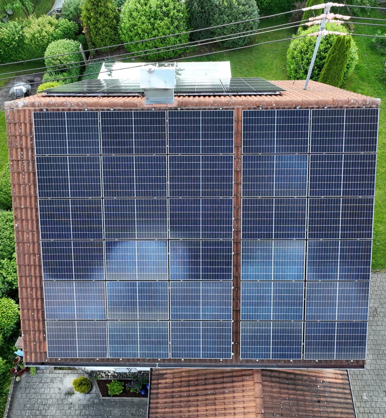 Aerial view of a residential rooftop with solar panels installed for renewable energy.