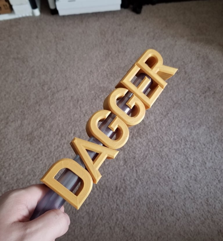 A 3d printed dagger with the blade forming the word dagger