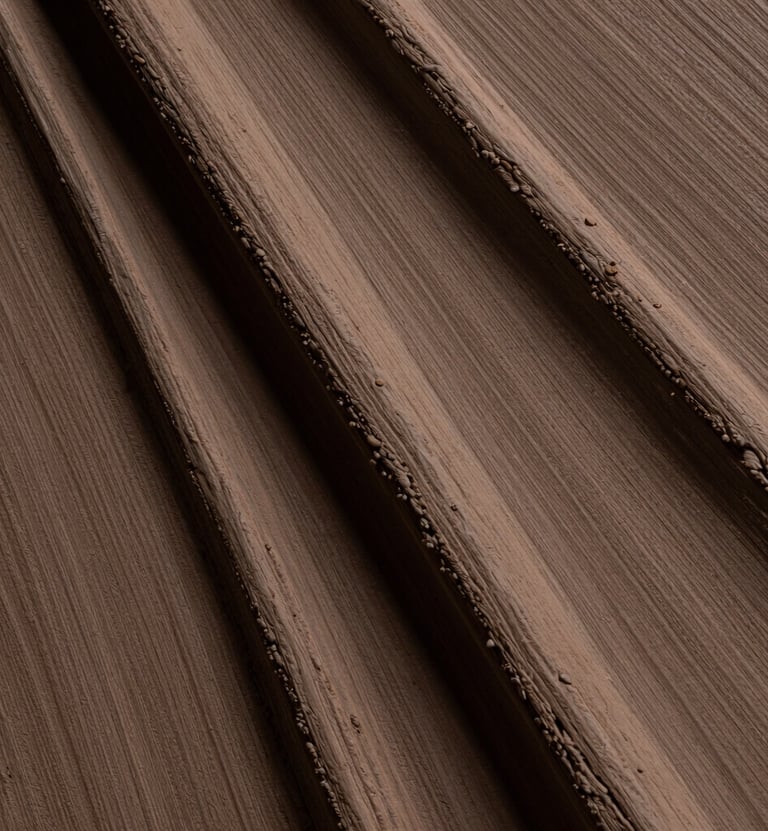 Macro photography showing the thick, tactile ridges of a painting created with muted earthy brown pigments. The lighting is low and directional, emphasizing the physical presence of the material. Artistic mood in a South American / Argentine studio.