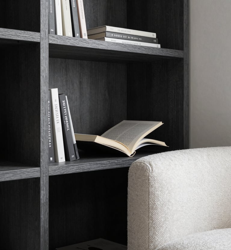 A close-up of a designer reading nook in a South American apartment, featuring a charcoal wood bookshelf and a comfortable off-white textile armchair, elegant soft lighting, professional photography.