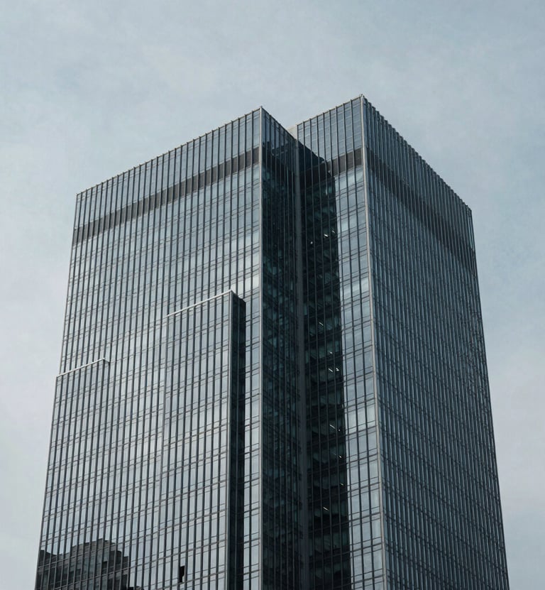 A minimalist architectural detail of a glass and steel skyscraper in a North American / US city, sharp geometric angles against a soft gray sky, high contrast lighting, cool blue-gray tones.