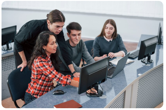 a group of people sitting around a computer