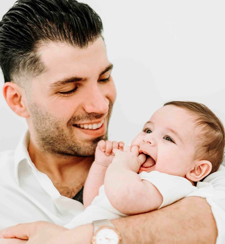 Father smiling while holding baby – Fred Art Studio family session