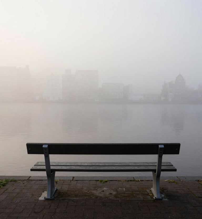 A minimalist, high-contrast photograph of a single empty bench overlooking a foggy canal in Amsterdam. The water is a dark charcoal, the fog is a soft off-white. Quiet, Northern European morning atmosphere, editorial style.