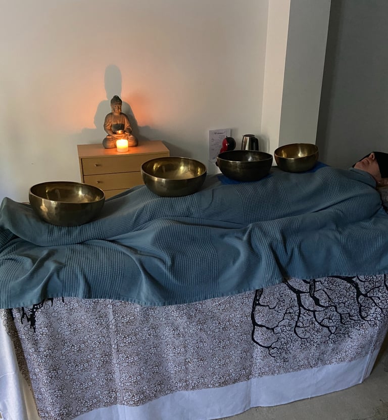 a person laying down receiving sound theraphy session with bowls