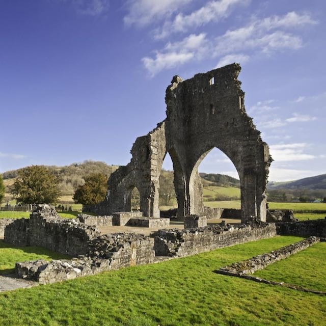 A beautiful ruined stone arch in a grassy field