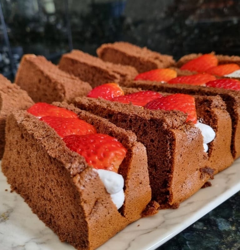 a cake with strawberries and whipped cream on a white plate