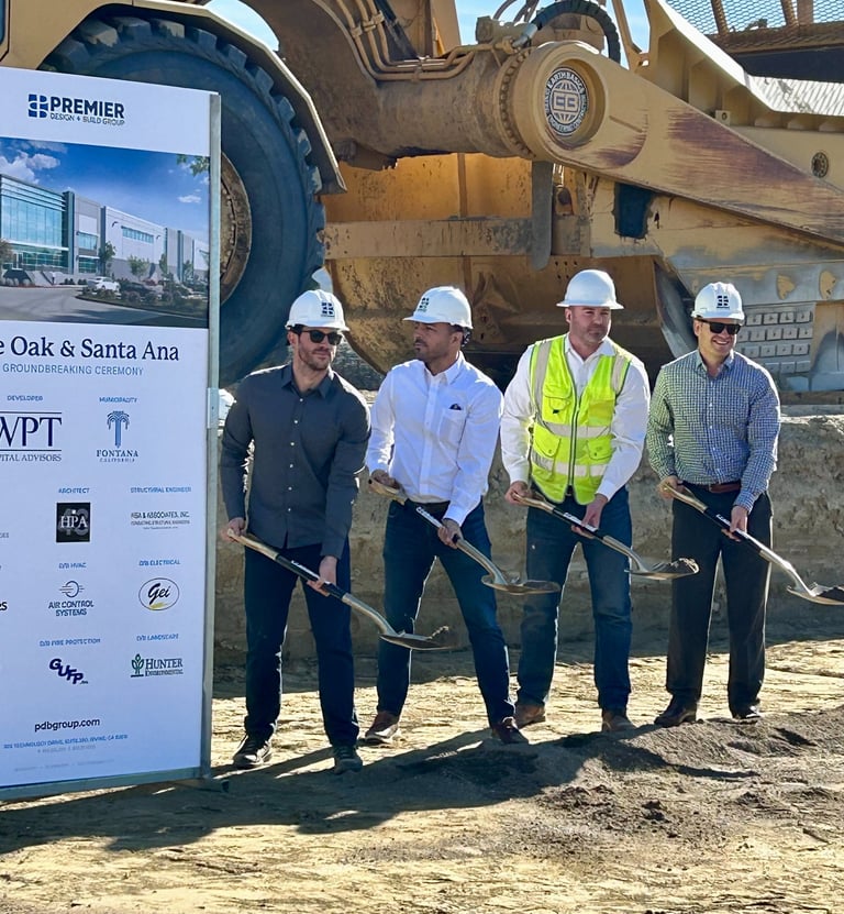 a group of people standing around a large sign ground breaking event planner