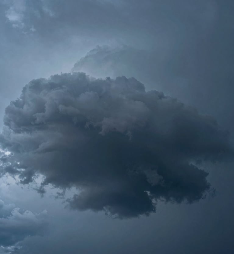 A minimalist macro photograph of a heavy storm cloud, showcasing textures of deep charcoal and steel blue, dramatic side-lighting highlighting the vapor, clean and atmospheric composition, International / Western style.