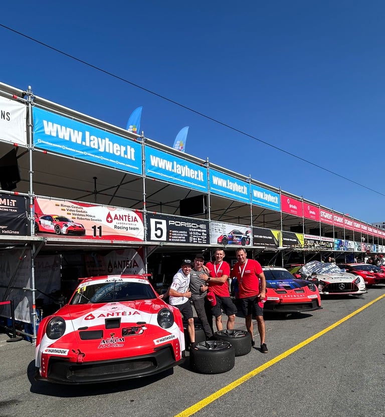 an Enlab group of people standing around a Porsche car in front of a building
