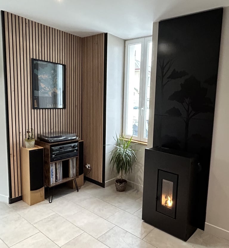 Poêle à granulés noir design avec flamme visible, intégré dans un salon moderne avec mur en tasseaux