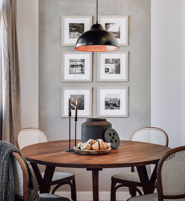 Elegant dining area with rattan and wood chairs and rustic decor elements by SAVIA interior design