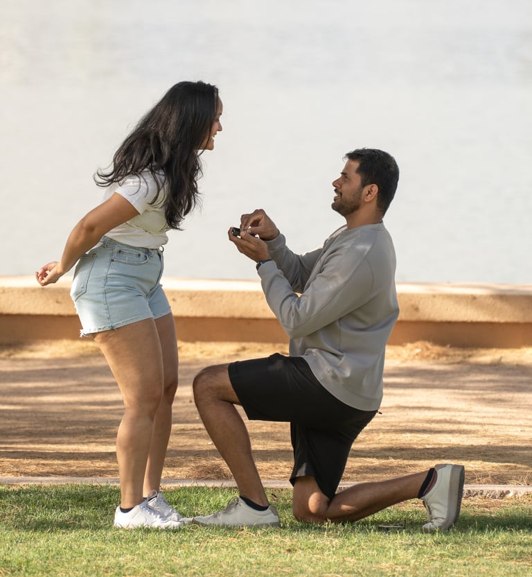 a man proposing a woman in shorts and a white shirt
