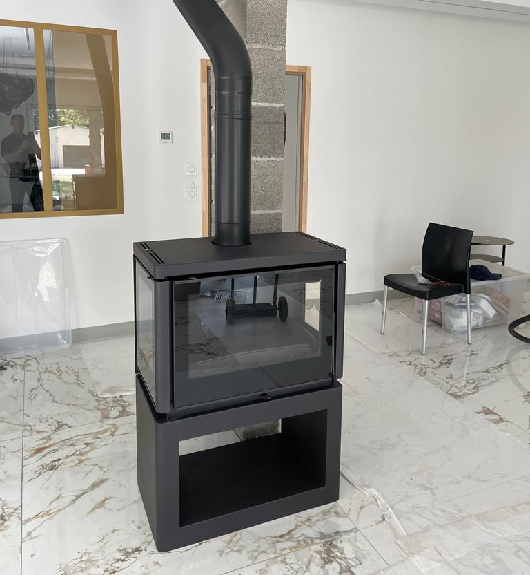 Installation de poêle à bois moderne avec conduit apparent