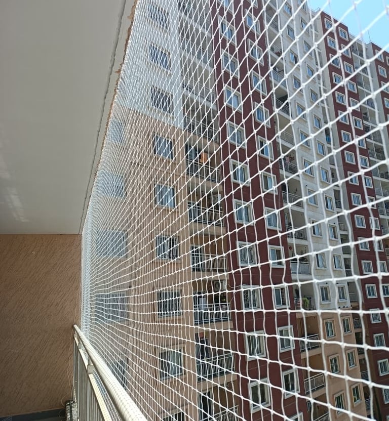 Wide shot of a multi-story apartment balcony secured with a sturdy safety net