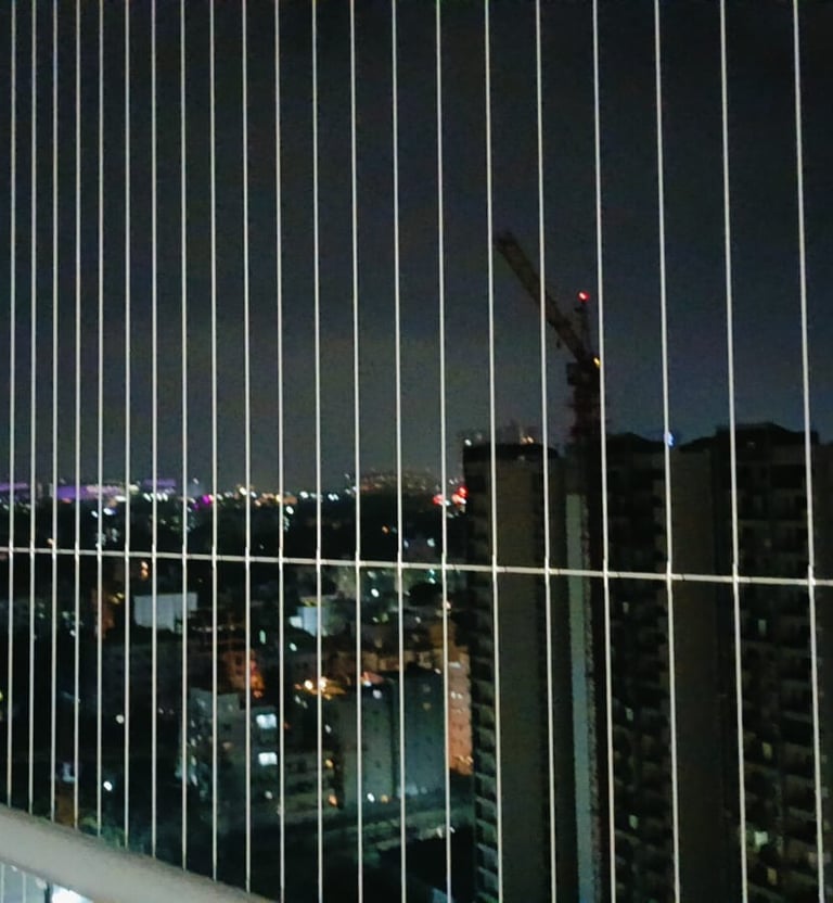 Wide shot of a sunlit balcony secured with practically invisible safety grills