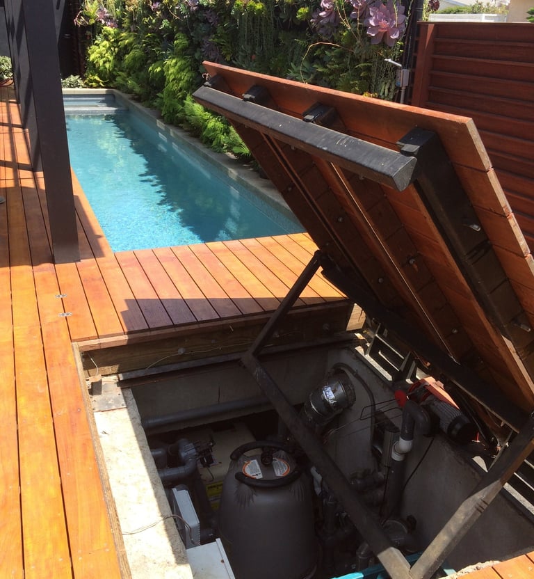 swimming pool built in liquefaction with sub-terranean equipment room and motorized hatch