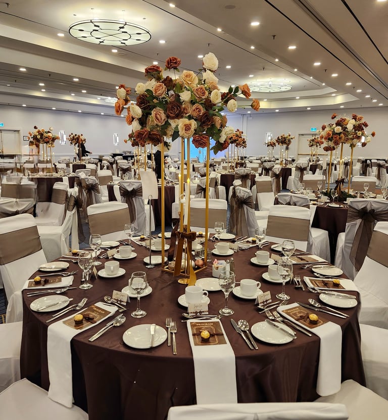  Luxury wedding reception table setup with tall gold floral centerpieces, brown and white table line
