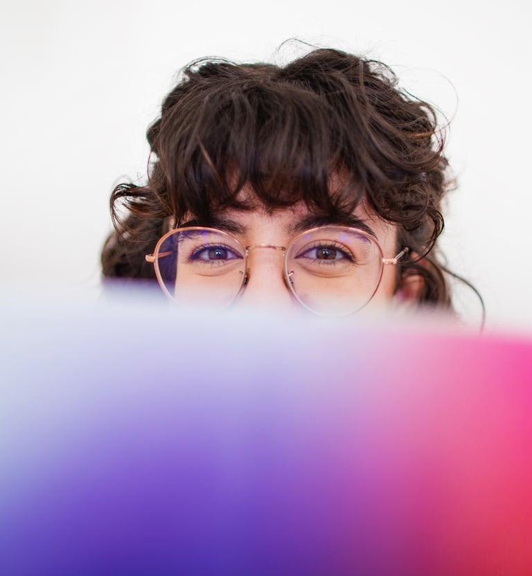 Fotografía de Blanca trabajando en su estudio tapada con un libro sobre paletas de color