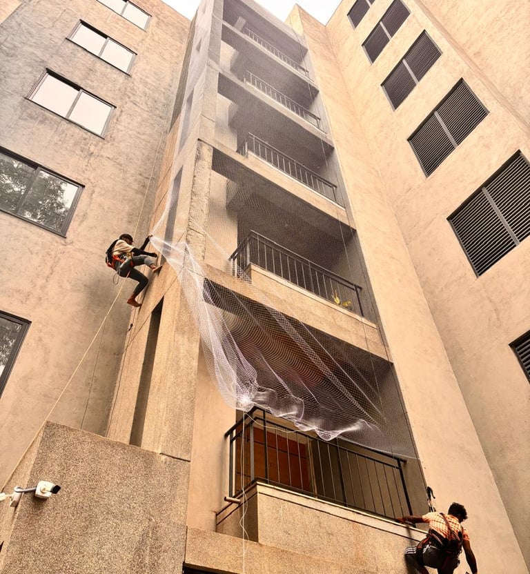 Wide-angle view of a spacious balcony fitted with durable safety nets overlooking the city skyline