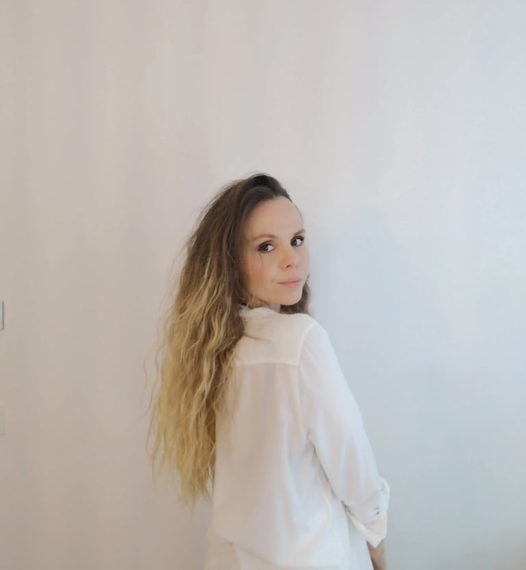 Christine Hauser, certified RTT Practitioner, wearing a white shirt and smiling over her shoulder