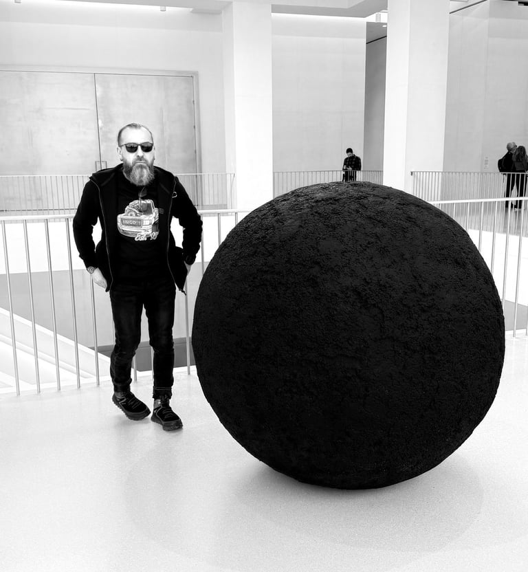 JEWELLER standing in front of a large black object