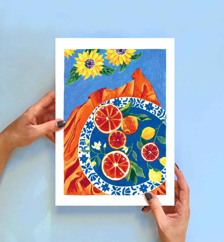 a person holding a painting of a plate with oranges