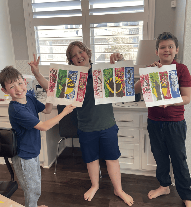 Happy kids proudly showing their colorful tree paintings at Kelley's Neighborhood Art