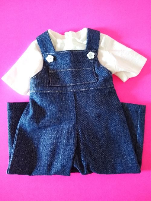 Handmade denim overalls and white T-shirt set for 18-inch dolls, displayed on a bright pink backgrou