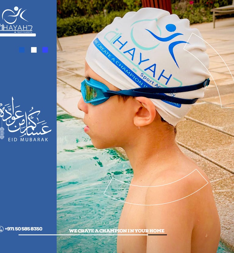 Young swimmer wearing blue goggles and a white Hayah Sport Academy swim cap at a pool.