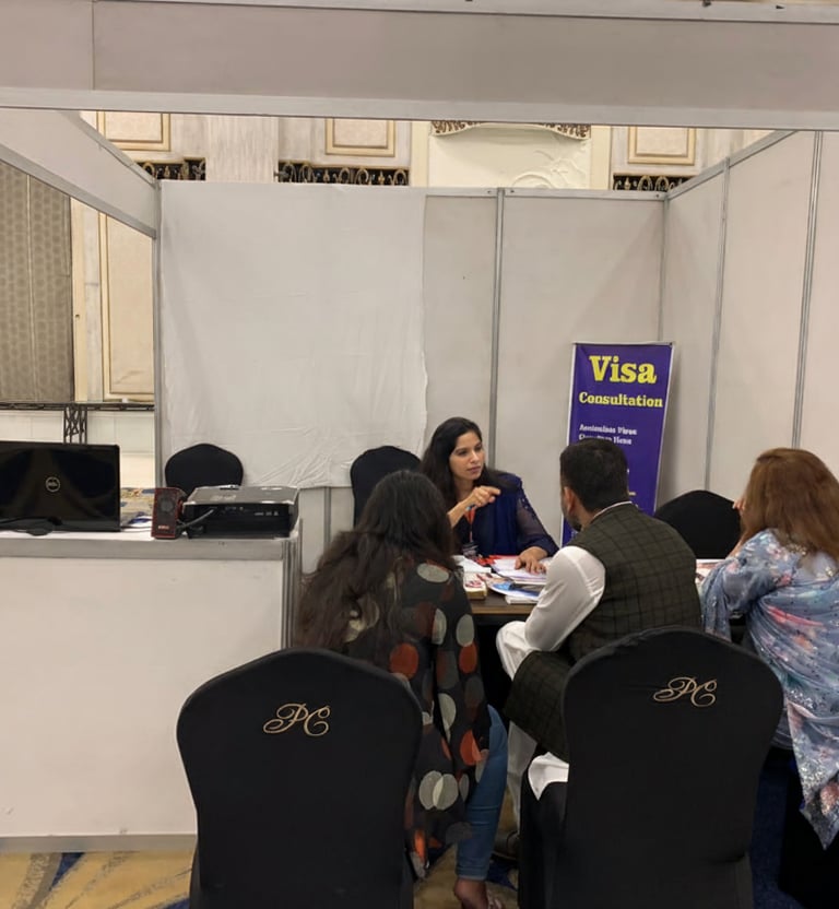 "Immigration consultant advising clients at a visa consultation booth during an event
